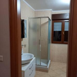 a bathroom with a glass shower and a sink at Golden Apartment in Tirana