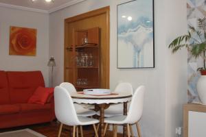 a living room with a table and white chairs at BIENVENIDOS a CASA PINO CENTRO in Logroño