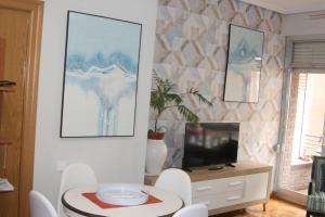 a living room with a tv and a table and chairs at BIENVENIDOS a CASA PINO CENTRO in Logroño