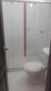 a bathroom with a toilet and a glass shower at Hotel Isla Capri in Mompós