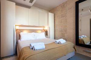a bedroom with a bed with two towels on it at Valletta Collection Orangerie 401 in Valletta