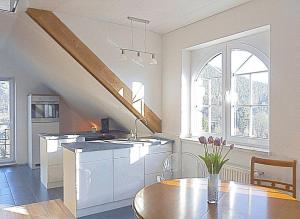 a kitchen and dining room with a table and a staircase at Ferienwohnung "Monte Noble" Südpfalz in Erlenbach