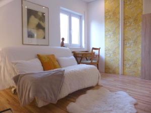 a bedroom with a white bed and a window at Ferienwohnung "Monte Noble" Südpfalz in Erlenbach