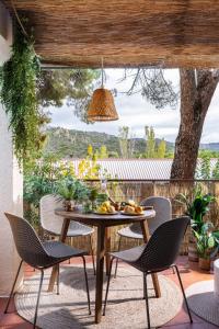 a table and chairs on a patio with a view of a tree at Costa Madrid Apartment 2bed in San Martín de Valdeiglesias