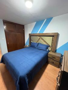a bedroom with a blue bed with a blue wall at Casa residencial Santa María in Oaxaca City