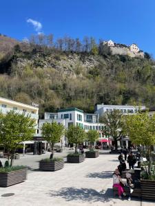 a group of people sitting on a bench in a town at Die möblierten Apartments in Triesen