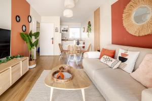 ein Wohnzimmer mit Sofa und Tisch in der Unterkunft F2 Ma Bohème classé 3 étoiles in Courcouronnes