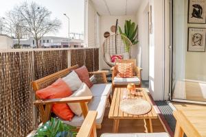 ein Balkon mit Stühlen, einer Couch und einem Tisch in der Unterkunft F2 Ma Bohème classé 3 étoiles in Courcouronnes