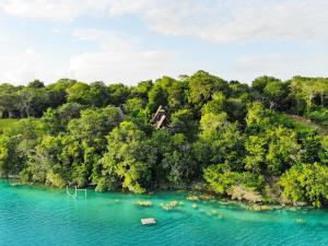 an island with a house in the middle of a lake at Azul Nomeolvides Bacalar - Lagoon Front in Bacalar