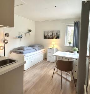 a small bedroom with a bed and a desk at Newly renovated studio apartment - free parking and EV docking in Trondheim