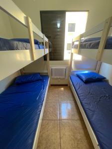 two bunk beds in a room with a window at Ubatuba Praia Das Toninhas - Salema 16B in Ubatuba