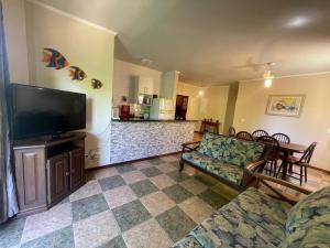 a living room with a couch and a flat screen tv at Ubatuba Praia Das Toninhas - Salema 16B in Ubatuba