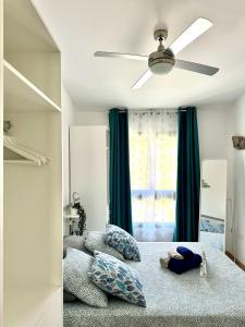 ein Schlafzimmer mit einem Deckenventilator und Kissen auf einem Bett in der Unterkunft Casita Feliz Ftv Luxury Apartment in Costa de Antigua