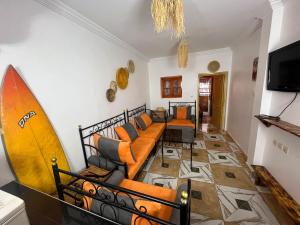 a living room with a couch and a surfboard at Heaven Surf Morroco in Tamraght Ouzdar