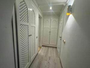 einen Flur mit weißen Türen und Holzboden in der Unterkunft Domina Coral Bay Sultan Tre in Sharm El Sheikh