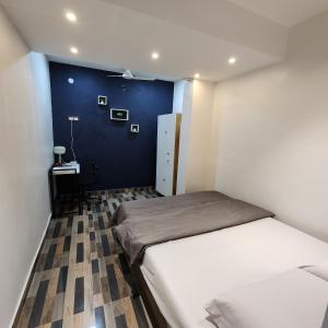 a bedroom with a bed and a blue wall at Stylish comfy Room near Airport in Chennai