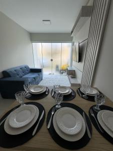 a dining room table with plates and wine glasses on it at Casa Arruda Climatizada 2 in Vitória da Conquista
