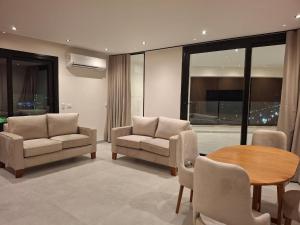 Una sala de estar con dos sillas y una mesa. en EGMS-CN-2 2BR apartment with fully Nile view, en El Cairo