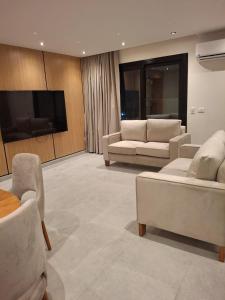 Una sala de estar con sofás y una mesa y sillas. en EGMS-CN-2 2BR apartment with fully Nile view, en El Cairo