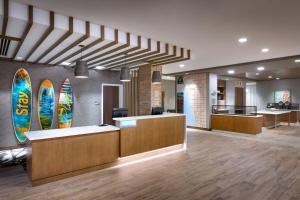 a hotel lobby with surfboards on the wall at TownePlace Suites by Marriott Los Angeles LAX/Hawthorne in Hawthorne +43 photos