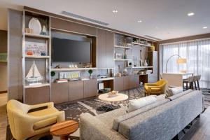 a living room with a couch and chairs and a tv at TownePlace Suites by Marriott Los Angeles LAX/Hawthorne in Hawthorne