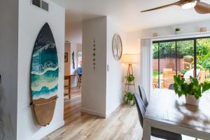 a dining room with a surfboard on the wall at Private House 3 min to beach large backyard Spa Sauna BBQ ! in San Juan Capistrano