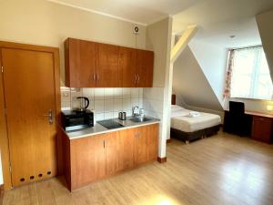 a kitchen with a sink and a bed in a room at HL Łebski Apartamenty in Łeba +37 photos