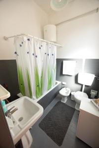a bathroom with a sink and a toilet and a shower curtain at Disiu Case Vacanza in Balestrate +67 photos