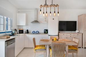 a kitchen with a table and chairs and a tv at Atlantic Soul in Playa Blanca