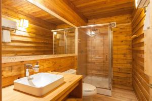 La salle de bains est pourvue de toilettes, d'un lavabo et d'une douche. dans l'établissement Suro Treehouse Resort, à Shogi