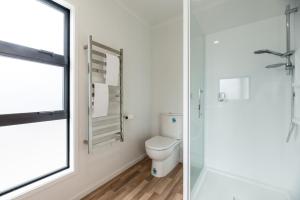 a bathroom with a toilet and a window at Edinburgh Escape - Waihi Beach Holiday Home in Waihi Beach +20 photos