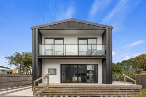 a small house with a black roof at Edinburgh Escape - Waihi Beach Holiday Home in Waihi Beach