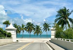 una strada vuota con palme e l'oceano di Seas the Keys Getaway a Duck Key