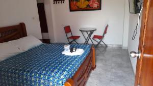 a bedroom with a bed with a table and chairs at Hotel Isla Capri in Mompos