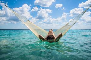 a person laying on a hammock in the water at Azul Nomeolvides Bacalar - Lagoon Front in Bacalar