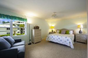 a bedroom with a bed and a couch and a window at Tamarind Bay # 16 in Grand Cayman +15 photos