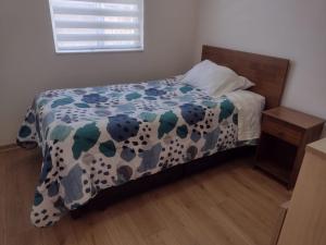 a bedroom with a bed with a dalmatian blanket at Acogedor Departamento en Temuco in Temuco