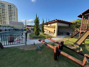 a group of logs on the grass next to a building at Casa Arruda Climatizada 2 in Vitória da Conquista