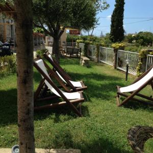 duas cadeiras de jardim sentadas na relva ao lado de uma árvore em Residenza Casale San Francesco em Tropea