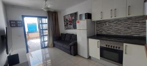 a kitchen and living room with a couch in it at Maspalomas J&O in Maspalomas