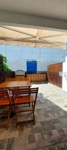a patio with wooden tables and a white canopy at Maspalomas J&O in Maspalomas