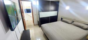 a small bedroom with a bed and a television at Maspalomas J&O in Maspalomas +11 photos