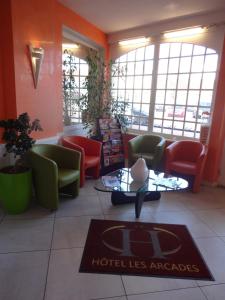 a lobby of a hotel with chairs and a table at Hôtel Des Arcades in Autun