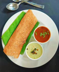 a white plate with a sandwich and a bowl of soup at Baga Ocean Way in Baga