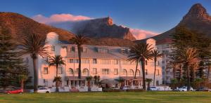 ein Gebäude mit Palmen vor einem Berg in der Unterkunft The Winchester Hotel by NEWMARK in Kapstadt