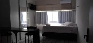 Un dormitorio con una cama y una mesa y una ventana. en Ap Central Master 02, en Campina Grande