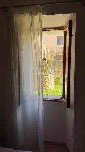 a window with a white curtain in a room at Can Bagot, Turismo de Interior in Llubí