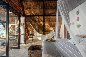 a bedroom with a hammock in a house at Azul Nomeolvides Bacalar - Lagoon Front in Bacalar
