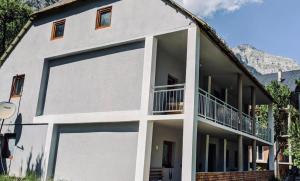 a white building with a large garage door at Guesthouse Mountain in Valbonë