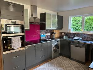a kitchen with stainless steel appliances and a washer and dryer at Callanish Bothy in Benderloch